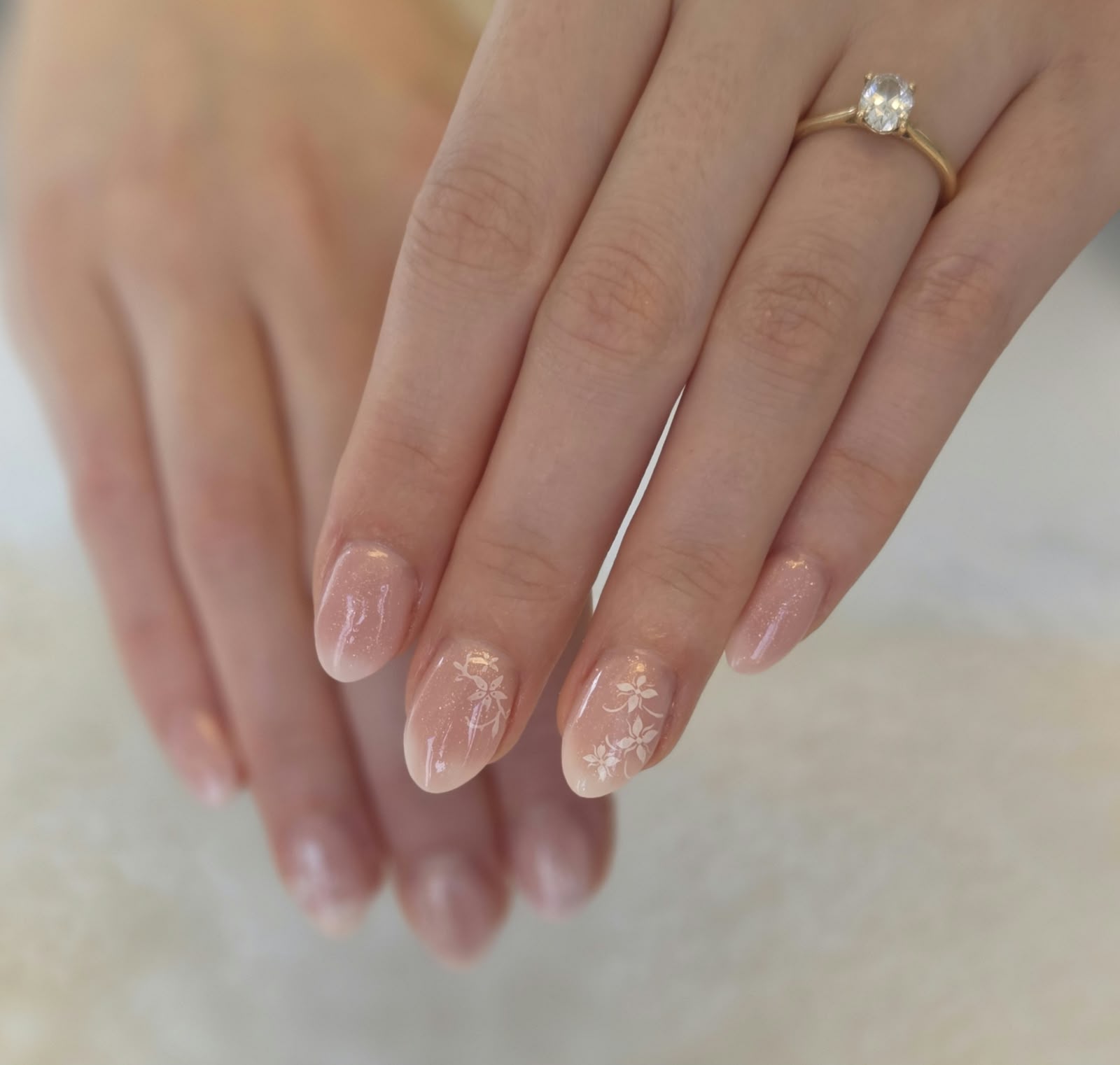 Rosé-Nägel mit weißen Blumen nach dem Nageldesign